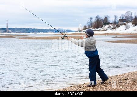 Junge mit einer Spinnrute auf dem Fluss Stockfoto