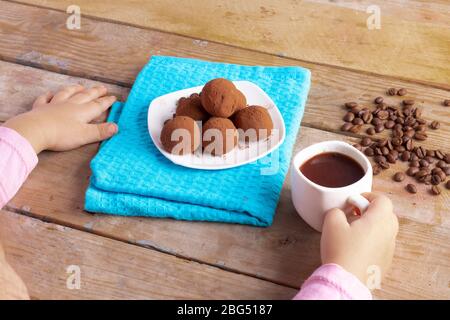 Vegan vegetarische rohe Snack, Kind hält Tasse Kaffee und Energie Bälle Stockfoto