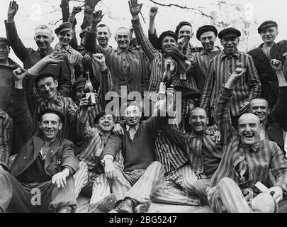 Dokumentation zum Zweiten Weltkrieg. Polnische Häftlinge des Konzentrationslagers Dachau stoßen auf ihre US-Befreier um April/Mai 1945 an Stockfoto