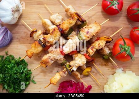 Set von Shish Kebabs . Beef Kebab auf einem Holzbrett . Rotkohl Sauerkraut . Kartoffelpüree . Knoblauch, Zwiebeln, Tomaten. Gehackter Koriander . Lamm Stockfoto