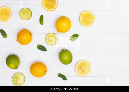 Bunte gelbe Zitronen in Scheiben geschnitten und halbiert mit Minzspritzen Stockfoto