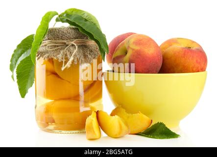 Glas von Pfirsichen aus der Dose und frischen Pfirsichen, isoliert auf weiß Stockfoto