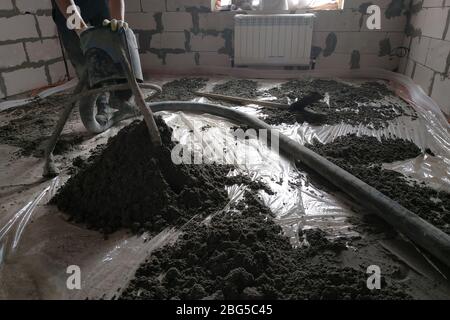 Baustelle - Maschine Bodenestrich, Rohre für Heizung und Fußbodenheizung.2020 Stockfoto