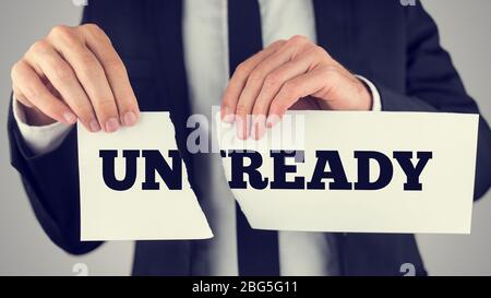 Nahaufnahme Konzeptunternehmer reißt ein White Paper mit unready - Ready Message isoliert auf einem grauen Hintergrund, getönter Retro-Effekt. Stockfoto