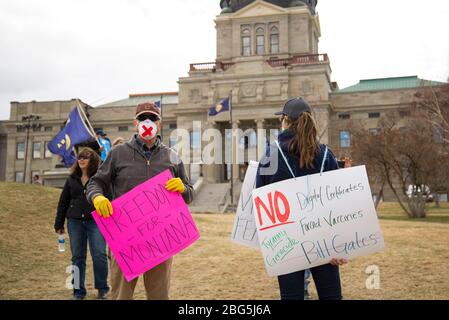 Helena, Montana - 19. April 2020: Demonstranten bei einem Protest im Kapitol, die Masken, Handschuhe tragen und Zeichen für Freiheit und gegen Impfstoffe halten, Stockfoto