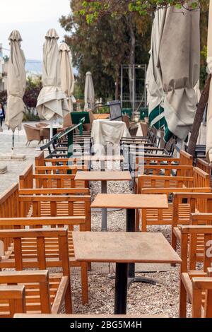 Leere Kaffeetische in Athen, in der berühmten Straße Apostolou Pavlou (Thissio) in der Nähe der Akropolis, während der Sperrung wegen des Coronavirus Ausbruch. Stockfoto