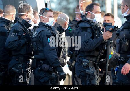 20. April 2020, Sachsen, Chemnitz: Polizisten mit Gesichtsmasken überwachen eine Kundgebung des rechtsextremen Vereins Pro Chemnitz vor dem Karl-Marx-Denkmal. Die Kundgebung fand unter strengen Bedingungen statt: Die Teilnehmerzahl war auf 15 begrenzt, außerdem war keine Demonstration erlaubt und es musste ein Mindestabstand von zwei Metern zwischen den Teilnehmern eingehalten werden. Außerdem musste eine Gesichtsmaske getragen werden und das Ereignis durfte nicht länger als eine Stunde dauern. Pro Chemnitz hielt das Treffen unter dem Motto "Wir wollen raus! End State Willkür' ursprünglich registriert Stockfoto