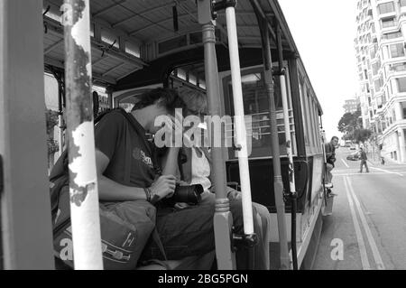 San Francisco Seilbahn Tasche Touristenpfade Elektrokabel Seilbahn Tour Straßenfahrt Leute Schlafstange sitzen sitzen sitzen sitzen sitzen sitzen sitzen sitzen und nach draußen schauen Stockfoto