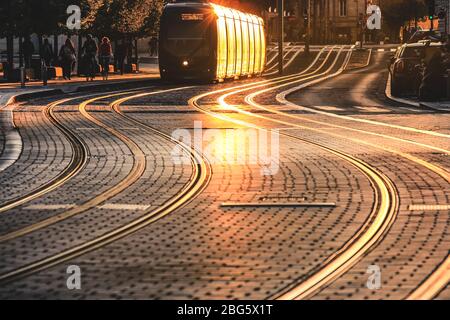 BORDEAUX, FRANKREICH - 1. SEPTEMBER 2017 : Stadtstraßenszene mit Straßenbahn bei Sonnenuntergang in Bordeaux, Frankreich Stockfoto