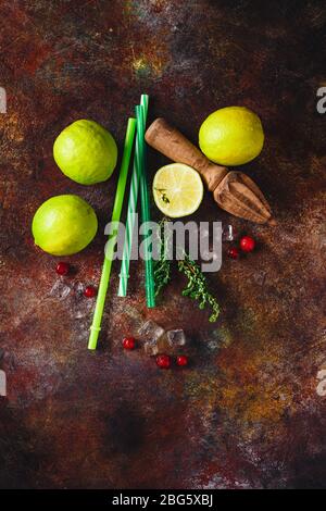 Zutaten für Limettenade mit Thymian, Cranberry und Eis auf dunklem Hintergrund. Draufsicht Stockfoto