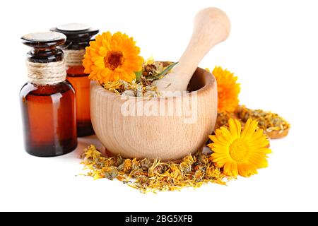 Arzneiflaschen und Ringelblumen in Holzmörtel auf weiß isoliert Stockfoto