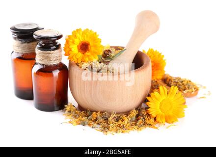 Arzneiflaschen und Ringelblumen in Holzmörtel auf weiß isoliert Stockfoto