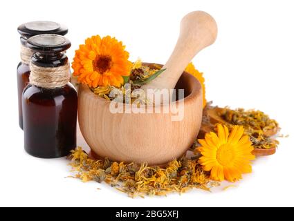 Arzneiflaschen und Ringelblumen in Holzmörtel auf weiß isoliert Stockfoto