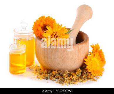 Arzneiflaschen und Ringelblumen in Holzmörtel auf weiß isoliert Stockfoto