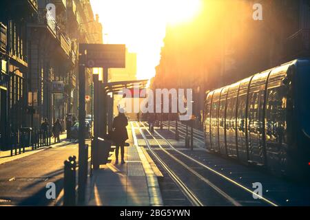 BORDEAUX, FRANKREICH - 1. Oktober 2017 : Stadt Straßenszene, selektive Fokus auf Menschen, die auf der Straße mit Straßenbahn während des Sonnenuntergangs in Bordeaux, Frankreich Stockfoto