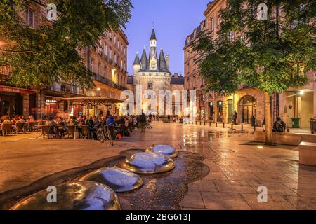 BORDEAUX, FRANKREICH - 19 Januar, 2017 : Blick auf die historische Porte Cailhau bei Nacht mit Menschen beim Abendessen auf der Terrasse des Restaurants in Bordeaux, G Stockfoto