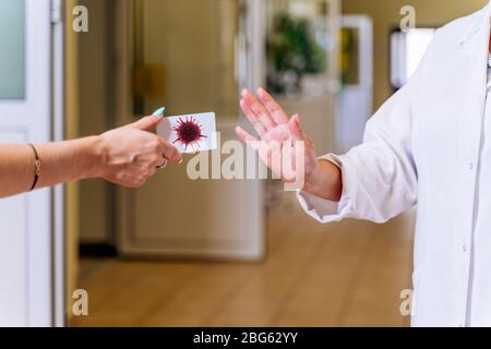 Mittleres Alter, Ärztin im Krankenhauskorridor, zeigt Stop mit Hand oder Handfläche zu Coronavirus oder covid 19 Ausbreitung der ansteckenden Krankheit Stockfoto