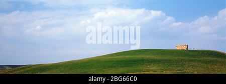 Italien. Toskana. Grüne Hügel mit Haus auf einem Hügel. Stockfoto
