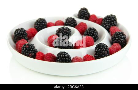 Reife Himbeeren und Brombeeren in Platte auf weiß isoliert Stockfoto