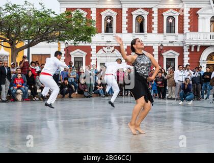 Tänzer in Kostümen, die Festejo traditionelle afro-peruanische Tänze zu den Massen auf dem Hauptplatz von Trujillo im Norden Perus aufführen Stockfoto