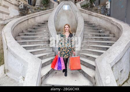 Attraktive niedliche Mädchen mit den bunten Einkaufstaschen in ihren Händen. Camondo Treppen (türkisch: Kamondo Merdivenleri) im Galata Bezirk in Istanbul, Türke Stockfoto