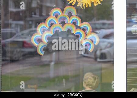 Regenbögen werden von Kindern an Fenster geklebt, um Dankbarkeit und Unterstützung für die Beschäftigten im Gesundheitswesen in der Gemeinde zu zeigen Stockfoto