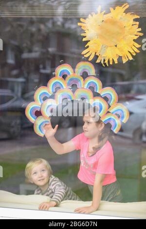 Regenbögen werden von Kindern an Fenster geklebt, um Dankbarkeit und Unterstützung für die Beschäftigten im Gesundheitswesen in der Gemeinde zu zeigen Stockfoto