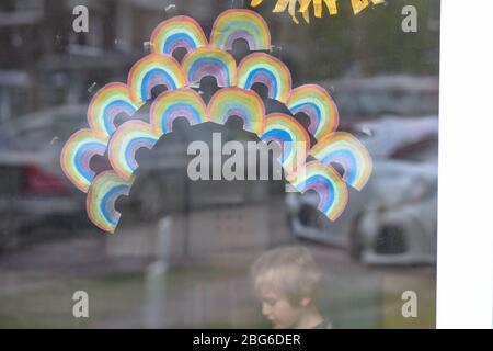 Regenbögen werden von Kindern an Fenster geklebt, um Dankbarkeit und Unterstützung für die Beschäftigten im Gesundheitswesen in der Gemeinde zu zeigen Stockfoto