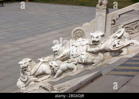 Chinesische Löwen und Fledermäuse sind in Stein gemeißelt. Jade Buddha Park, Anshan, Provinz Liaoning, China, Asien. Stockfoto