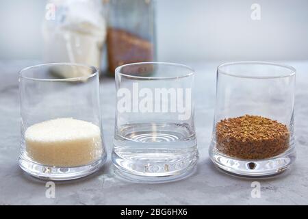 Schritt 1. Zusammensetzung und Proportionen für die Herstellung von Dalgona Kaffee. Kaffee, Zucker und Wasser im Verhältnis 1:1:1. Stockfoto