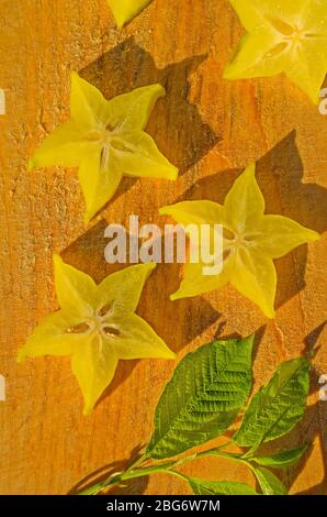 Sternfrucht, Karambola mit grünen Blättern auf Holzhintergrund Stockfoto