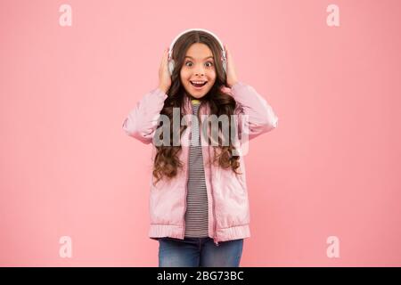 Das klingt großartig. Schallschwingungen. Musik und Technologie. Audio-Sound. Spaß und Unterhaltung. Musik ein. Glückliches Kind genießen Sie hören Soundtrack. Kleines Mädchen tragen Kopfhörer rosa Hintergrund. Stockfoto