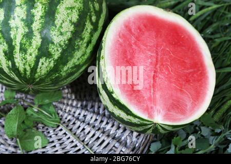 Reife Wassermelonen auf Weidenschale auf Gras Stockfoto