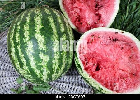 Reife Wassermelonen auf Weidenschale auf Gras Stockfoto