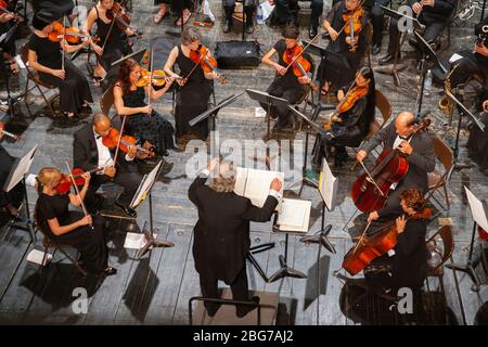 Overhead-Ansicht des Dirigenten führenden klassischen Orchester (alle Modell veröffentlicht) in der Performance. Stockfoto