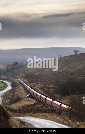 DB Fracht Merry gehen rund Kohle Zug mit importierten Kohle durch die Landschaft Landschaft auf der Settle Carlisle Bahnlinie bei Shotlock Hill Stockfoto