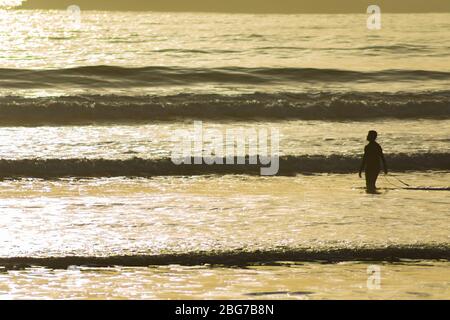 Silhouette eines Mannes und seines Surfbretts im Atlantik bei Sonnenuntergang in Essaouira Marokko Stockfoto