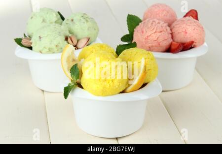 Leckere Eisbecher in Schalen, auf Holztisch Stockfoto