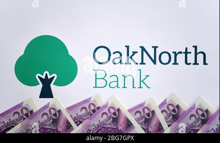 Stone / Großbritannien - April 15 2020: OakNorth Bank Logo auf der Broschüre mit Dollarscheinen auf der Oberseite gedruckt. Stockfoto