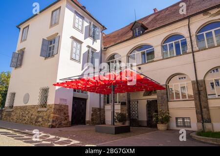 Maribor, Slowenien - 09. August 2019: Das rote Dach des Schirms vor dem Haupteingang des Regionalmuseums von Maribor Stockfoto