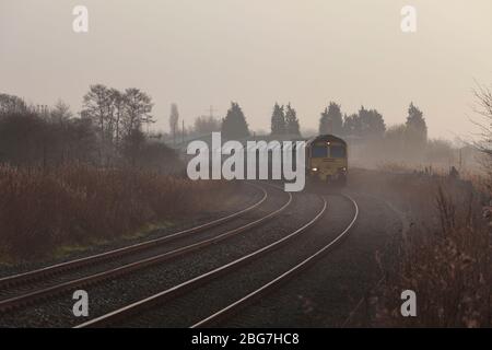 Freightliner 66/6 Diesellokomotive bei Fiddlers Ferry mit einem Güterzug, der Kalkstein auf der Warrington Low Level Line transportiert Stockfoto