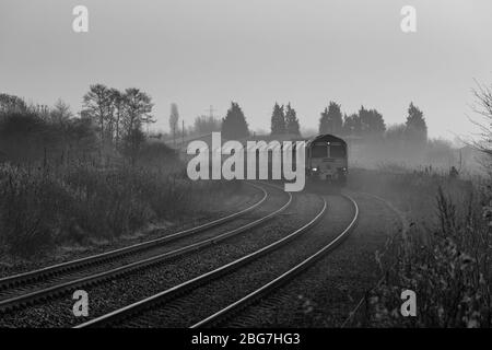 Freightliner 66/6 Diesellokomotive bei Fiddlers Ferry mit einem Güterzug, der Kalkstein auf der Warrington Low Level Line transportiert Stockfoto