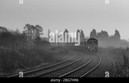 Freightliner 66/6 Diesellokomotive bei Fiddlers Ferry mit einem Güterzug, der Kalkstein auf der Warrington Low Level Line transportiert Stockfoto