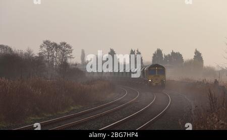 Freightliner 66/6 Diesellokomotive bei Fiddlers Ferry mit einem Güterzug, der Kalkstein auf der Warrington Low Level Line transportiert Stockfoto