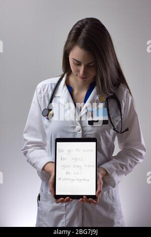 Weibliche Beschäftigte im Gesundheitswesen hält das Tablet in Richtung Kamera. Leer für Text oder Text, Technologie im Gesundheitswesen einschließlich weißer Schicht und Stethoskop Stockfoto