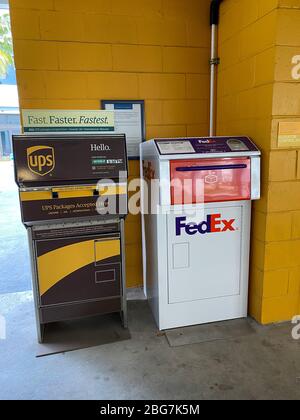 Orlando,FL/USA-4/10/20: Eine UPS und FedEx Drop Boxen in einer Garage neben einem Bürogebäude Stockfoto