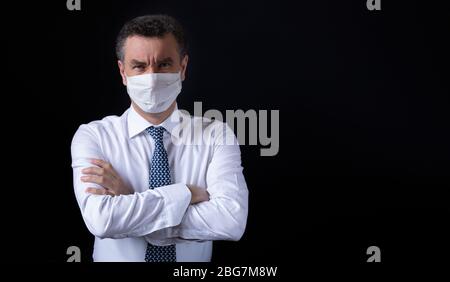 Furioser Boss, der die Arme auf schwarzem Hintergrund kreuzt Stockfoto