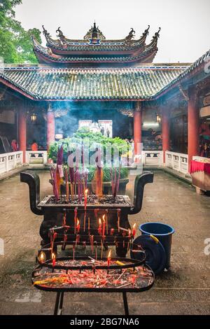 Fengdu, China - 8. Mai 2010: Geisterstadt, historisches Heiligtum. Hof mit schwerem Weihrauchgefäß und Brennstäbchen. Chinesische Architektur der Hallen und Stockfoto