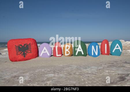 Albanien mit Nationalflagge, zusammengesetzt mit bunten Steinbuchstaben am Strand Stockfoto