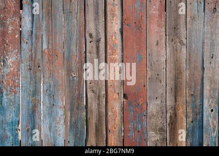 Holzhintergrund grau. Braune, graue, rote, blaue Holzstruktur. Vertikal angeordnete Nahaufnahme Holzplanken. Vertikale Holztafeln in Grau und Hellblau. Stockfoto